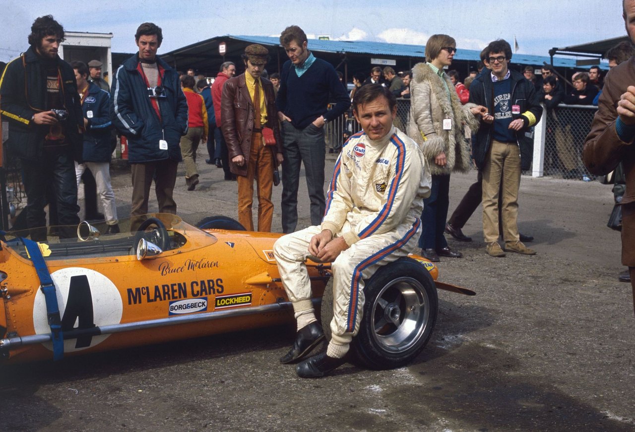 Marec 1970: novozelandski dirkač Bruce McLaren (1937–1970) sedi na kolesu svojega McLaren-Forda M14A pred začetkom Dirke prvakov na dirkališču Brands Hatch v Kentu.